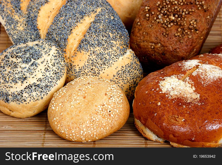 Different types of bread: long loaf with poppy, buns with poppy and with onion, bun with powdered sugar, rye-bread