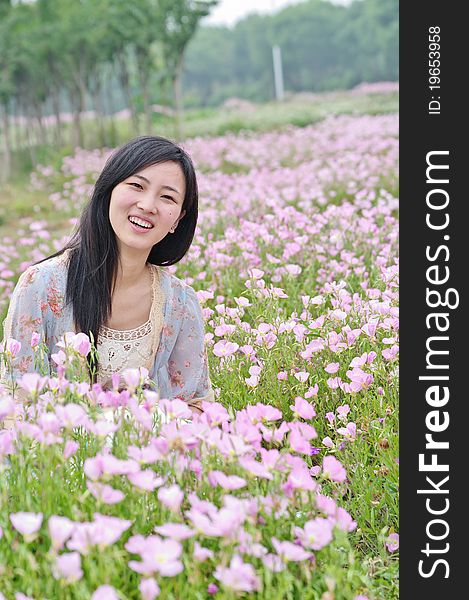 A girl in field with flowers around. A girl in field with flowers around