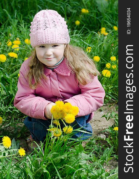 Portrait of the little girl with dandelions outdoor