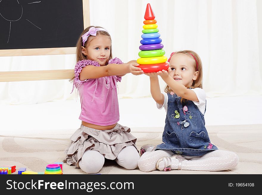 Two little girls play with toys