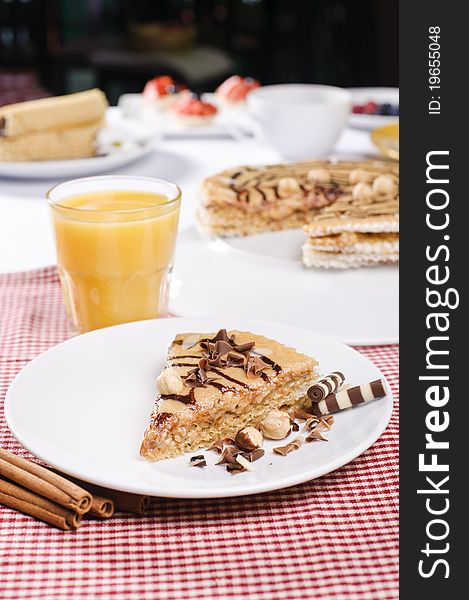 Piece of cake with chokolate and juice on white plate