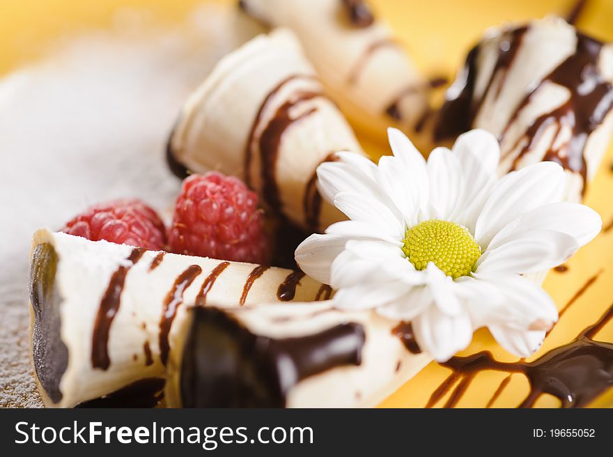 Piece of cake on plate with berries and fruits and camomile