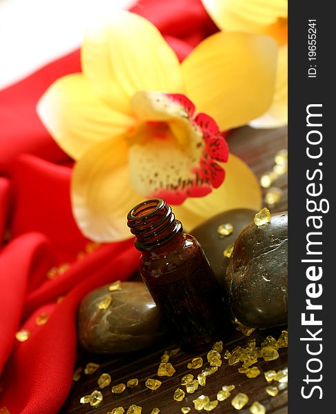 Bottle of essence oil, stones, bath salt and yellow flowers. Bottle of essence oil, stones, bath salt and yellow flowers