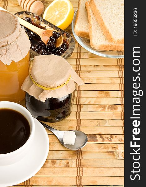 Coffee, honey and bread on straw table. Coffee, honey and bread on straw table