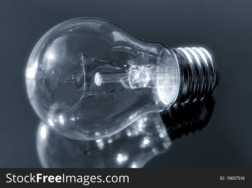 Close up of light bulb on a reflecting surface. Close up of light bulb on a reflecting surface