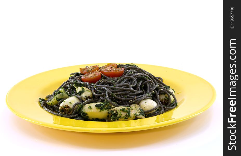 A yellow plate with black pasta and squid