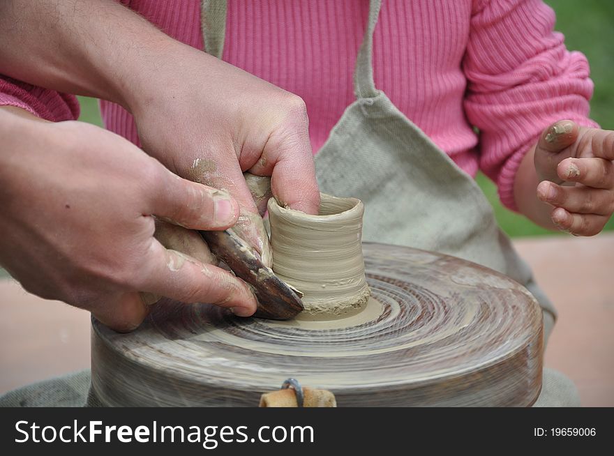 Hand of the master teaching pottery