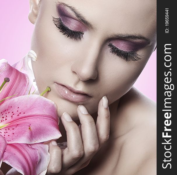 Portrait of a blond beauty with flowers on the pink background. Portrait of a blond beauty with flowers on the pink background