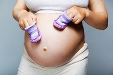 Pregnant Woman Holding Pair Of Shoes Stock Image