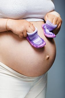 Pregnant Woman Holding Pair Of Shoes Stock Photography