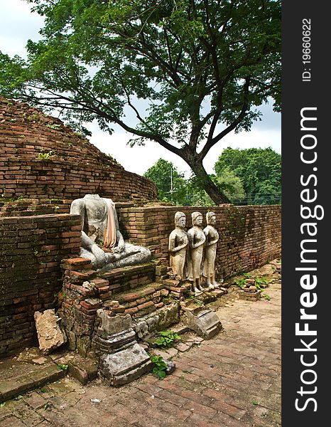 Ruin of pagoda and Buddha's statue with a big tree in Thailand. Ruin of pagoda and Buddha's statue with a big tree in Thailand