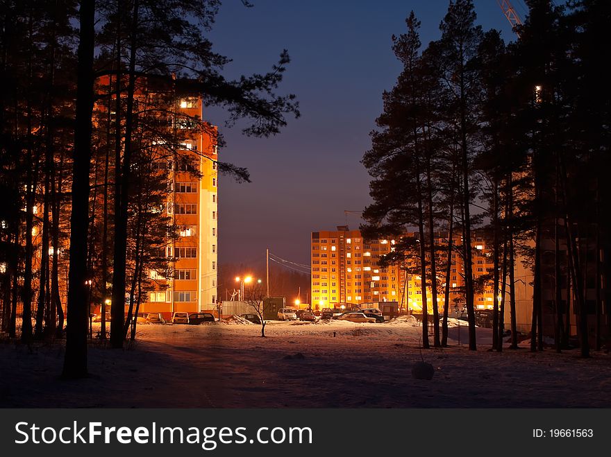 Bright illuminated city houses in forest. Bright illuminated city houses in forest