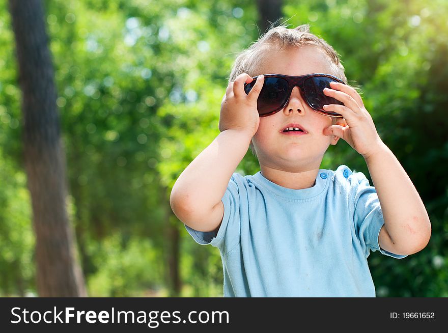 Cute 2 years old boy Sunglasses outdoors at sunny summer day. Cute 2 years old boy Sunglasses outdoors at sunny summer day