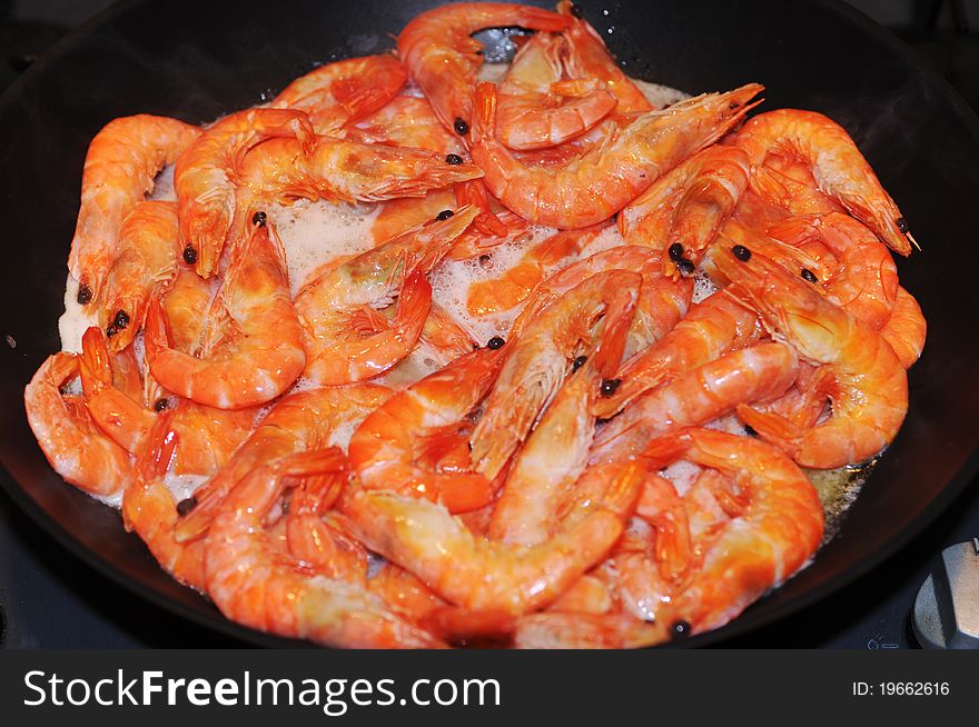 Red crown shrimps frying on pan