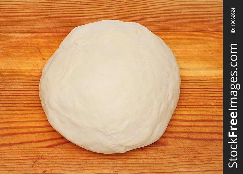 Dough on wooden cutting board