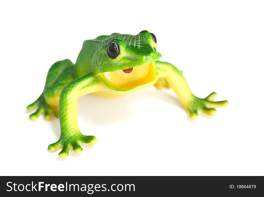 Green frog on white background. A plastic toy.