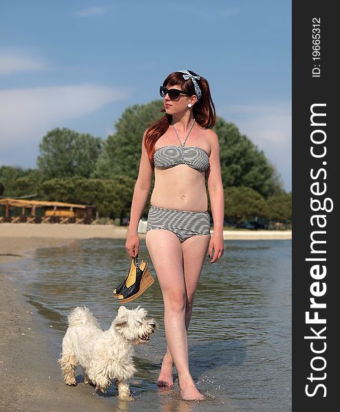 Retro girl having fun with her dog at the beach. Retro girl having fun with her dog at the beach