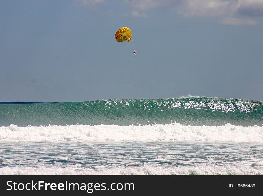 Parasailing over crashing waves in the Indian Ocean