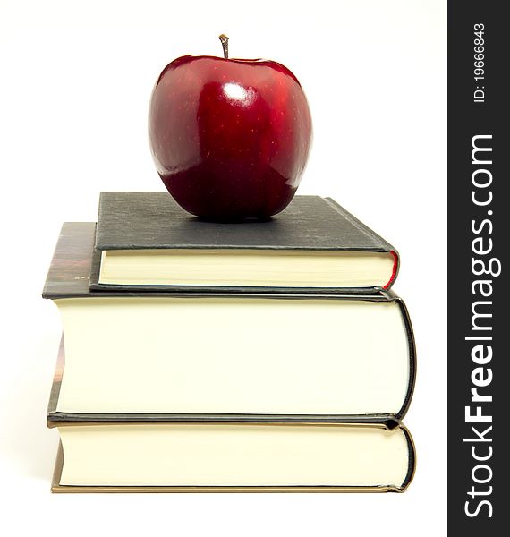 Close-up of red apple over books on white background. Close-up of red apple over books on white background