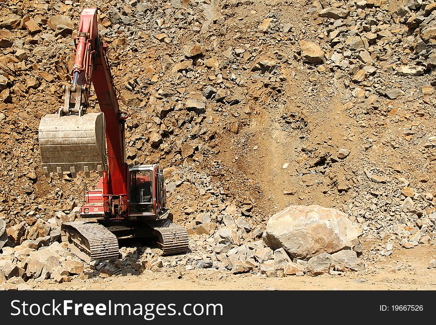 Stone quarry excavator at work and squashed rocks