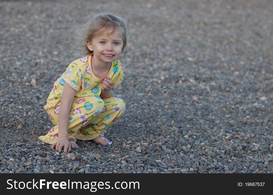 A photograph of a cute girl playing in the rocks.