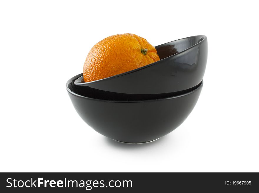 Orange and two ceramic black plates over white background