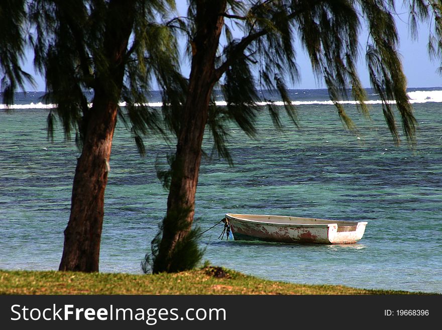 Beach scene with tranquil sea and deserted boat in Mauritius. Beach scene with tranquil sea and deserted boat in Mauritius.