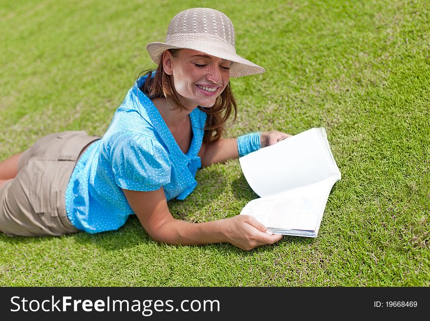 Happy woman with toothy smile lying down on a meadow. Happy woman with toothy smile lying down on a meadow