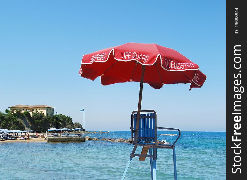 Red life guard umbrella, beach and sea view