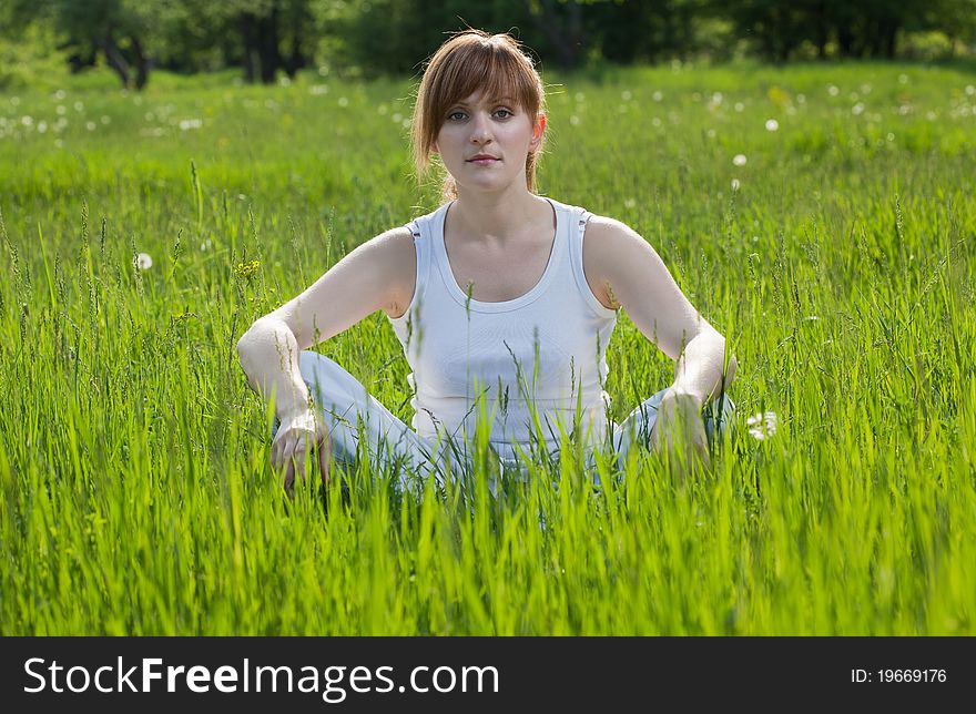 Photo about healthy lifestyle. Young woman doing yoga exercise in a park. Photo about healthy lifestyle. Young woman doing yoga exercise in a park