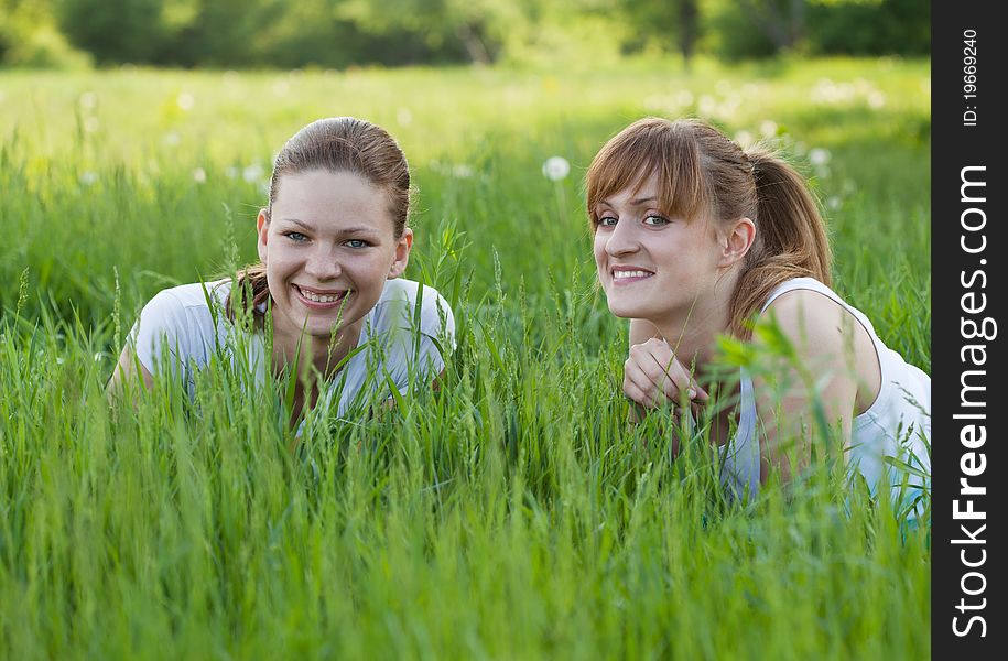 Happy Sisters Lying In  Grass