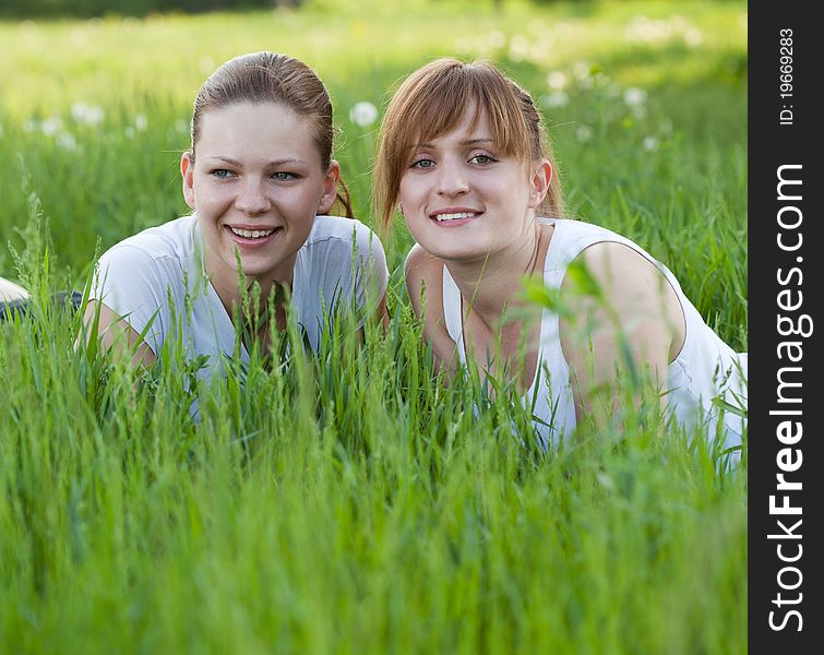 Two girls lying in a grass in the park zone. Two girls lying in a grass in the park zone