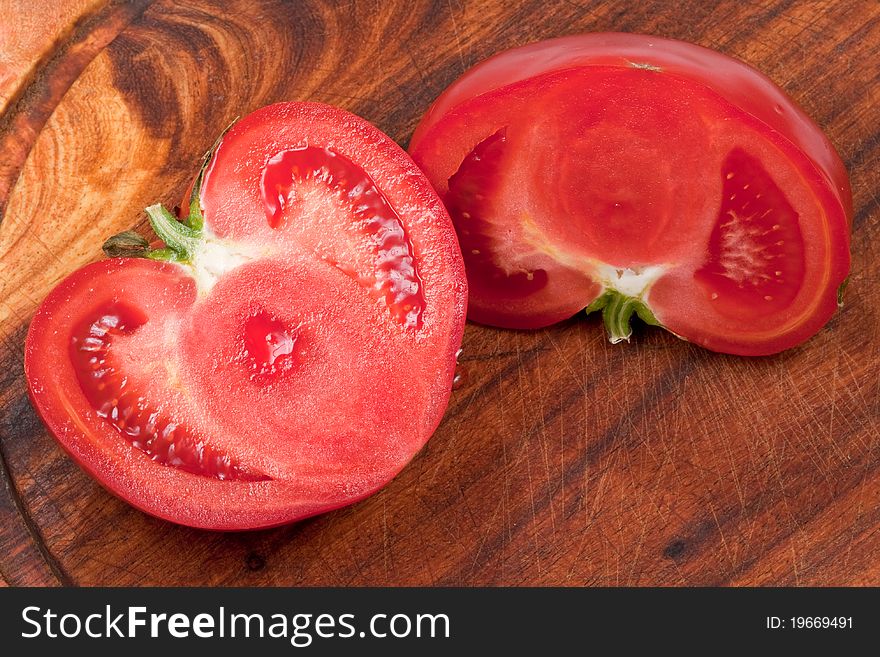 Splited red tomato on wooden board