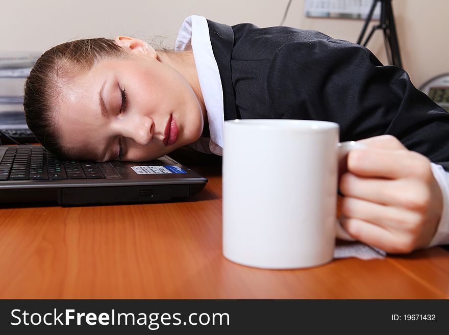 Young businesswoman in black suit sleeping on the laptop