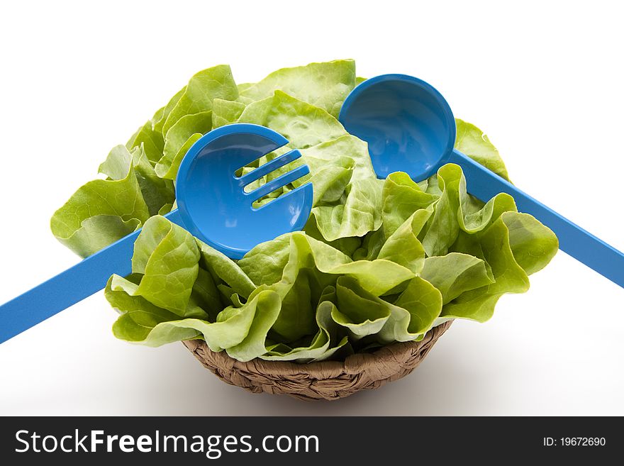 Head lettuce with salad servers in the basket