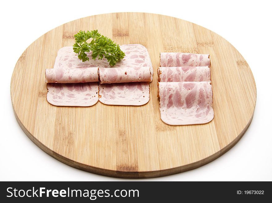 Rolled ham sausage and with parsley onto wood plates