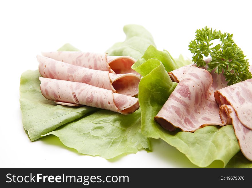 Ham sausage with parsley on lettuce leaf