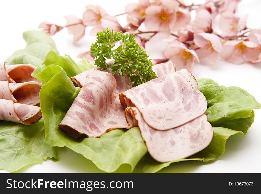 Ham sausage on lettuce leaf with flower