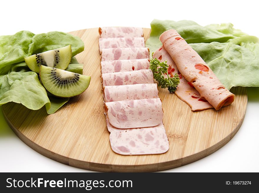 Sausage plate with leaf vegetable and kiwi