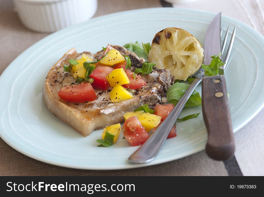 Southern-style pork chop with mango and tomatoes