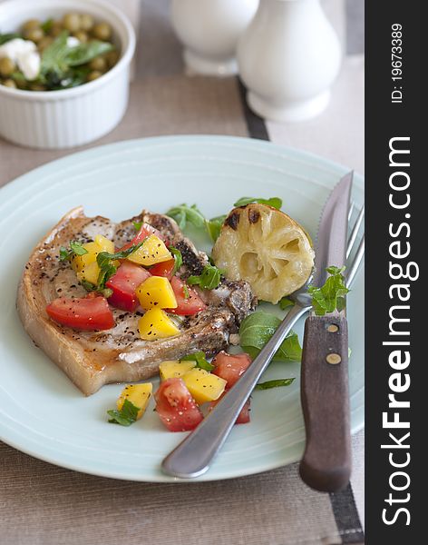 Southern-style pork chop with mango and tomatoes