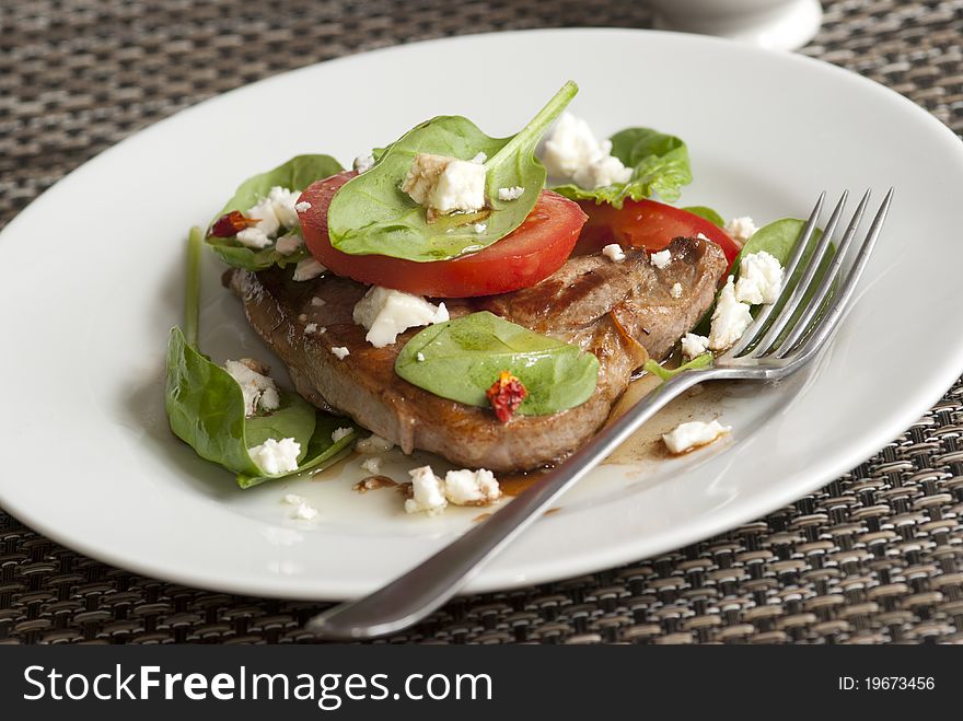 Steak with tomatoes, spinach and feta cheese