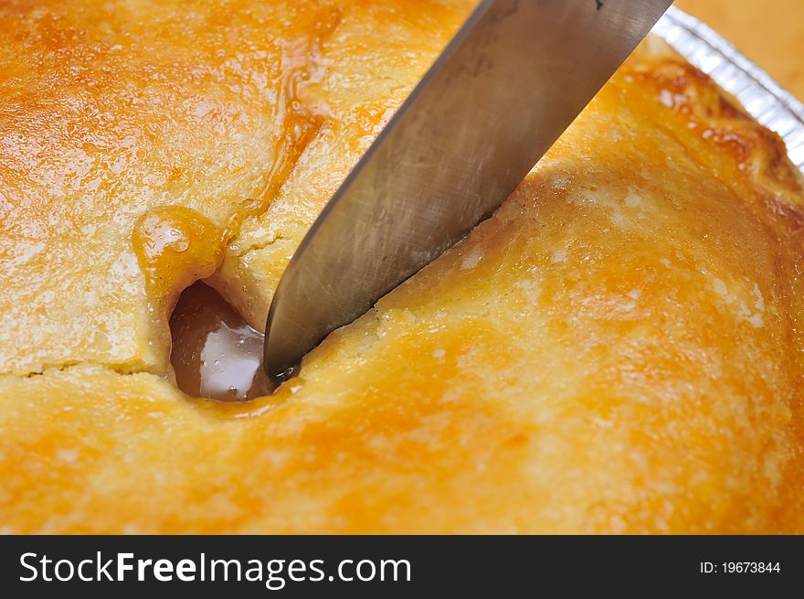 Closeup shot of knife cutting into delicious fruit pie. Closeup shot of knife cutting into delicious fruit pie