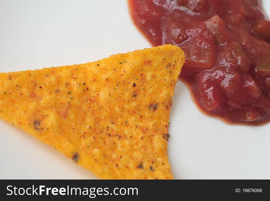 Close up view of single chip with tomato sauce on white background.