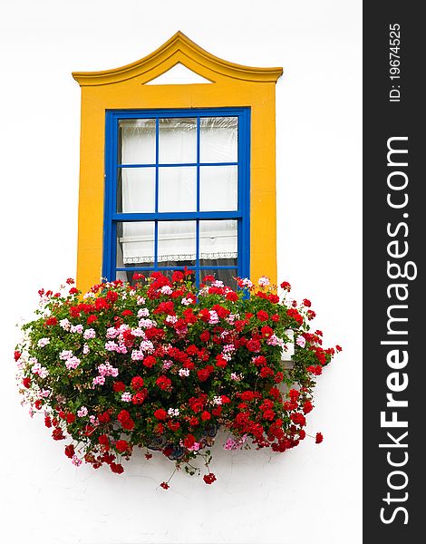 Traditional window with bright colors yellow and blue with many colorful red flowers. Traditional window with bright colors yellow and blue with many colorful red flowers