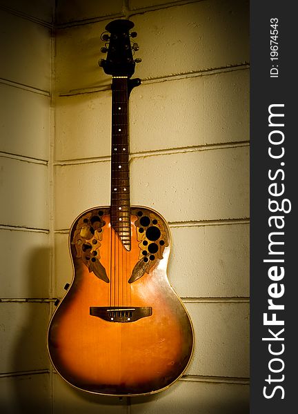 Old acoustic guitar hanging on the old wall. Old acoustic guitar hanging on the old wall