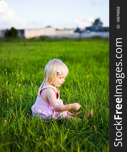 A young girl in a green field of long grass. A young girl in a green field of long grass