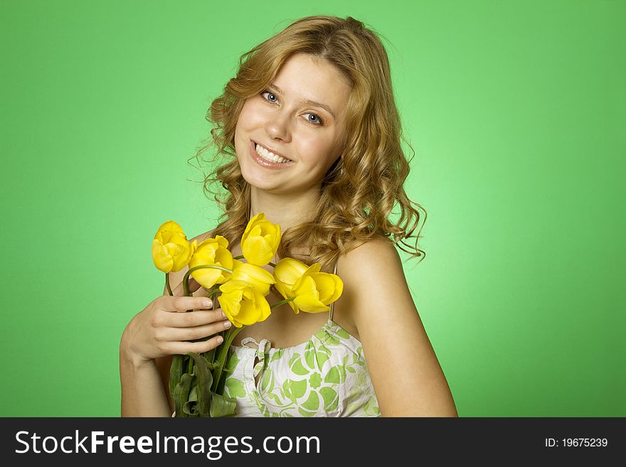 HappyClose up on a green background Happy young woman hugging a yellow tulip. Young Woman Hugging Flower. HappyClose up on a green background Happy young woman hugging a yellow tulip. Young Woman Hugging Flower