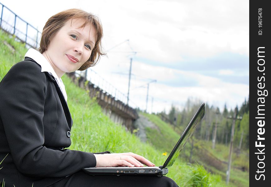 Business woman with laptop in nature.