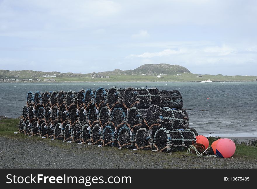 View from Fionnphort on the Isle of Mull, Scotland towards the Isle of Iona with lobster pots used in the local fishing industry visible in the foreground. View from Fionnphort on the Isle of Mull, Scotland towards the Isle of Iona with lobster pots used in the local fishing industry visible in the foreground.